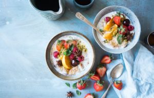 two bowls of healthy oatmeal topped with fresh fruit
